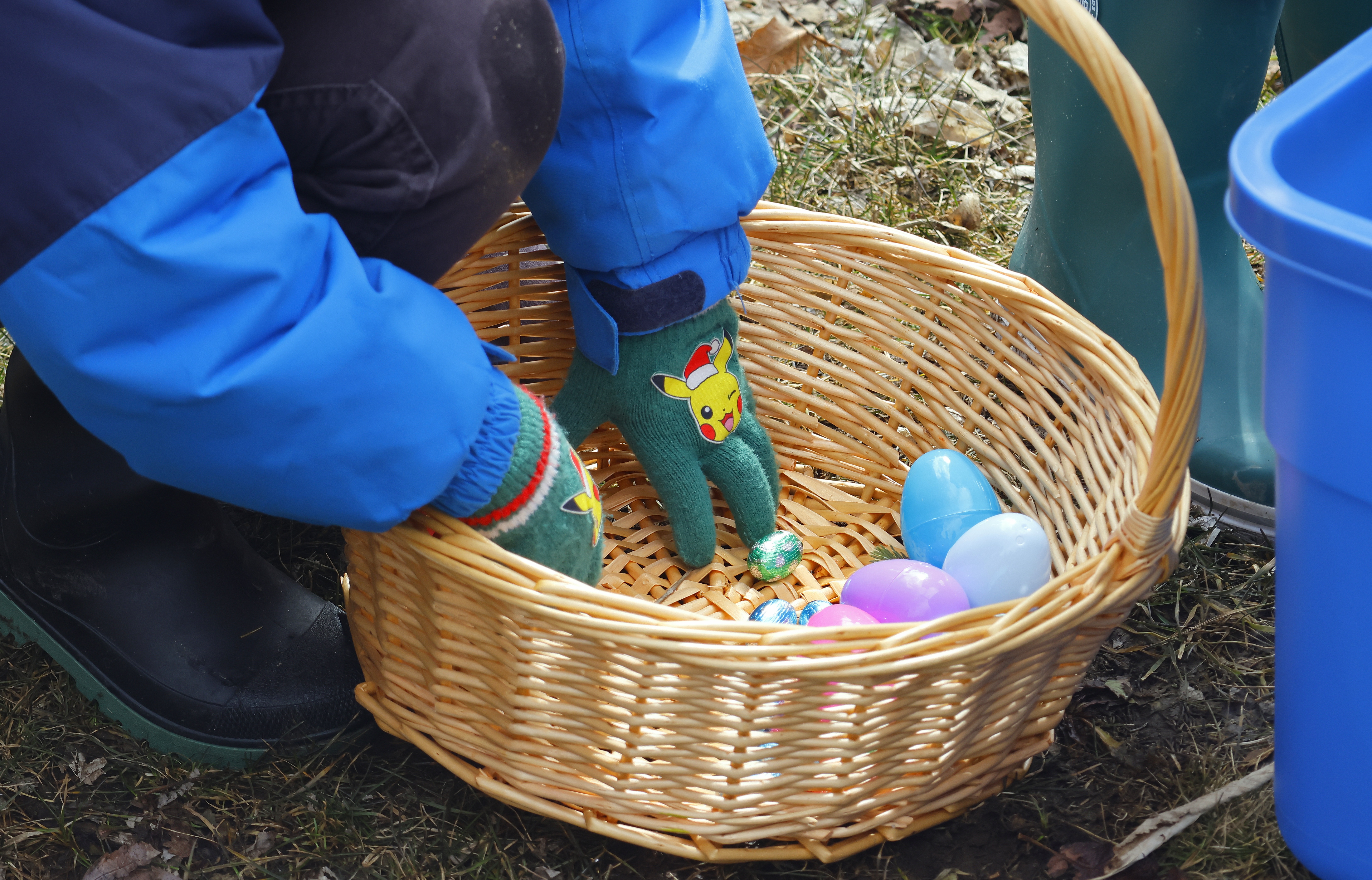 Child hands in a basket with some easter eggs.